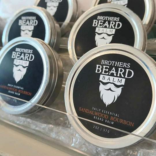 Multiple jars of Brothers Beard Balm on a reflective surface