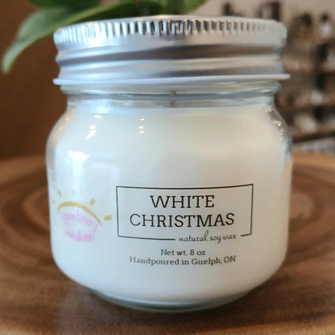 Candle jar labeled 'White Christmas' on a wooden surface